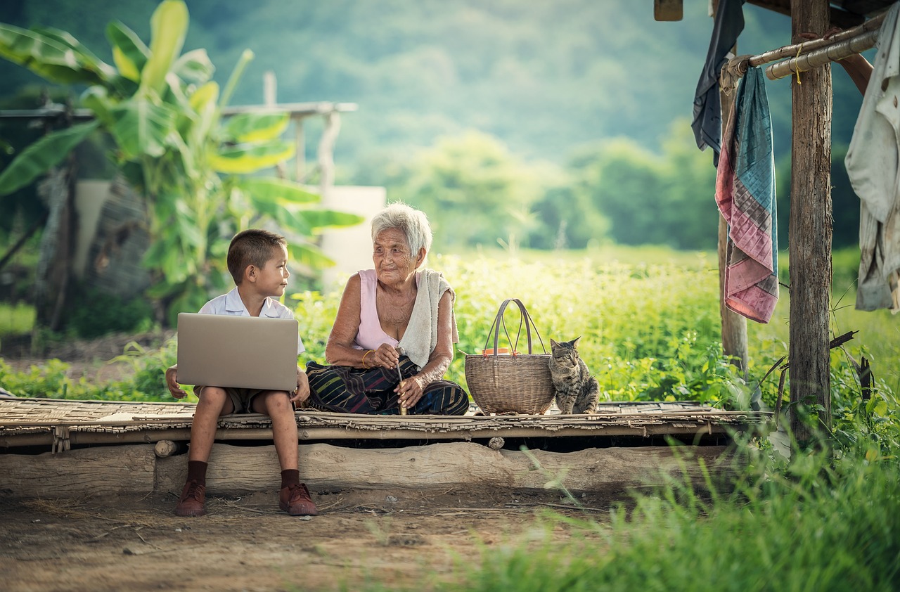 boy holding a laptop with elderly woman | everyday in Cambodia